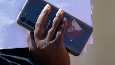 Una de las migrantes sostiene su celular, con una fotografía en la funda, a su llegada a un centro de ayuda humanitaria tras ser liberado por la Patrulla Fronteriza de Estados Unidos tras cruzar el río Bravo y entregarse a las autoridades para solicitar asilo, el 22 de septiembre de 2021, en Del Rio, Texas.