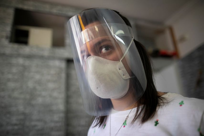 Francis Murillo, de 29 a&ntilde;os, usa un escudo facial que hizo con material reciclado donado y una impresora 3D para ayudar a prevenir el contagio del nuevo coronavirus en su tienda en Caracas, Venezuela, el lunes 13 de abril de 2020.&nbsp;