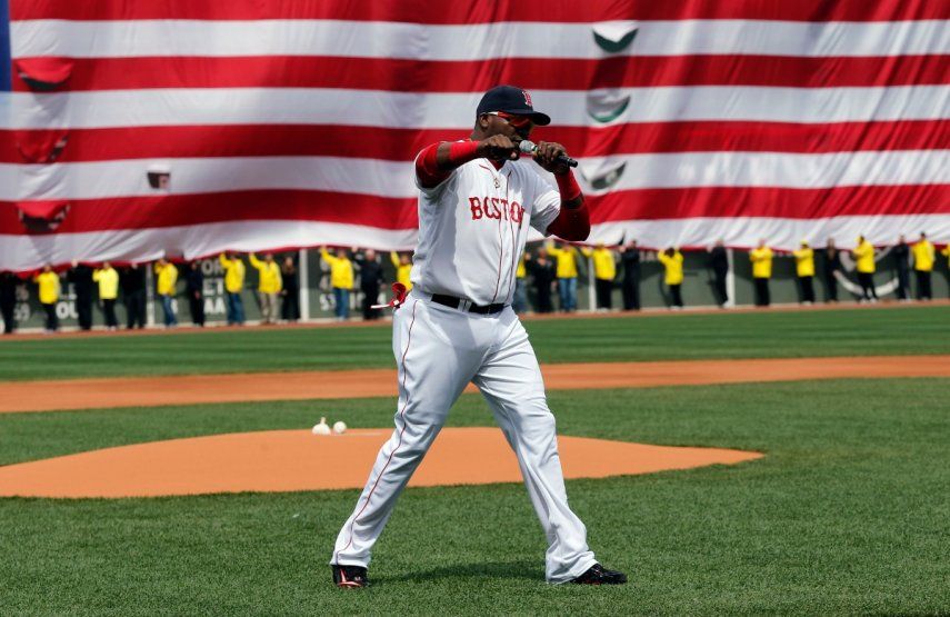David Ortiz, de los Medias Rojas, habla de forma efusiva con la bandera de Estados Unidos de fondo, sujetada por voluntarios del Maratón de Boston, el 21 de abril de 2013.