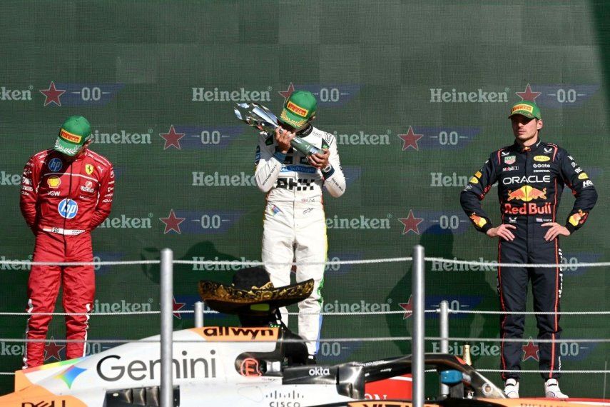 El piloto británico de McLaren, Lando Norris (C), besa el trofeo en el podio junto a sus similares de Ferrari, el monegasco Charles Leclerc (L), que quedó en segundo lugar, y el holandés de Red Bull Racing, Max Verstappen (D), tercero, después de ganar el Gran Premio de Fórmula 1 de la Ciudad de México en el autódromo Hermanos Rodríguez, el 26 de octubre de 2025.