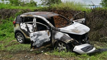 Los restos de un vehículo incinerado presuntamente utilizado por los asesinos de un coronel de las Fuerzas Armadas del Ecuador aparecen al costado de una carretera en Guayaquil, Ecuador, el 14 de febrero de 2025.