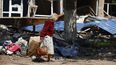 Una civil camina entre un inmueble destruido en Mariúpol, territorio bajo control del gobierno de la República Popular de Donetsk, en el este de Ucrania, el viernes 27 de mayo de 2022.&nbsp;