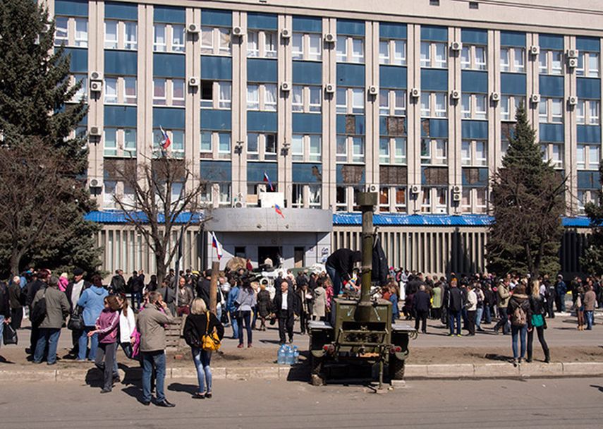 Activistas prorrusos se congregan frente a la entrada de la oficina del Servicio de Seguridad ucraniana en Luhansk, 30 kilómetros (20 millas) al oeste de la frontera con Rusia, en Ucrania, el martes 8 de abril de 2014. (AP)