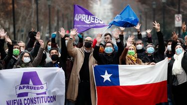 En esta foto de archivo tomada el 6 de julio de 2022, personas ondean mientras sostienen banderas de aprobación de la nueva Constitución y una bandera chilena en Santiago.
