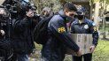 Policías confiscan una caja de documentos durante un allanamiento judicial en el Hotel Plaza Central donde se aloja la tripulación de un avión de carga Boeing 747 de propiedad venezolana, en Buenos Aires, Argentina, el martes 14 de junio de 2022. 
