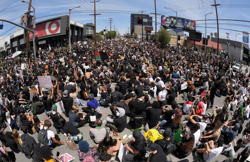 En esta imagen tomada con un gran angular, manifestantes sentados en un cruce durante una protesta por la muerte de George Floyd, un hombre negro que murió tras ser detenido por la policía en Minneapolis, el sábado 30 de mayo de 2020 en Los Ángeles. 