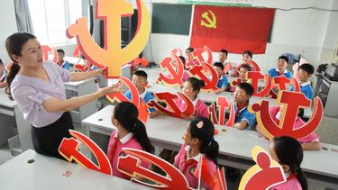 En esta foto de archivo, una maestra y sus alumnos posan con emblemas del Partido Comunista durante una clase sobre la historia del Partido Comunista en una escuela en Lianyungang, en la provincia oriental china de Jiangsu el 28 de junio de 2020. Estados Unidos dijo el 16 de julio de 2020 todas las opciones estaban abiertas para presionar a China.