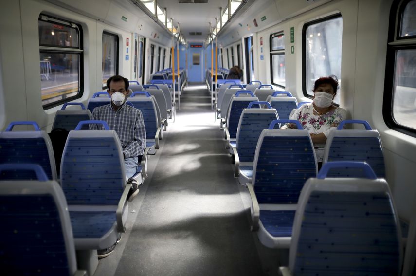 En esta foto de archivo del 20 de marzo de 2020, personas con máscaras como medida de precaución en medio de la propagación del nuevo coronavirus viajan en un tren vacío en Buenos Aires, Argentina.