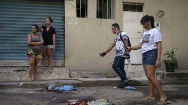 Residentes de acarezinho toman fotografías de pertenencias cubiertas de sangre de personas asesinadas durante un operativo policial contra presuntos narcotraficantes en la favela Jacarezinho en Río de Janeiro, Brasil, el 6 de mayo de 2021.