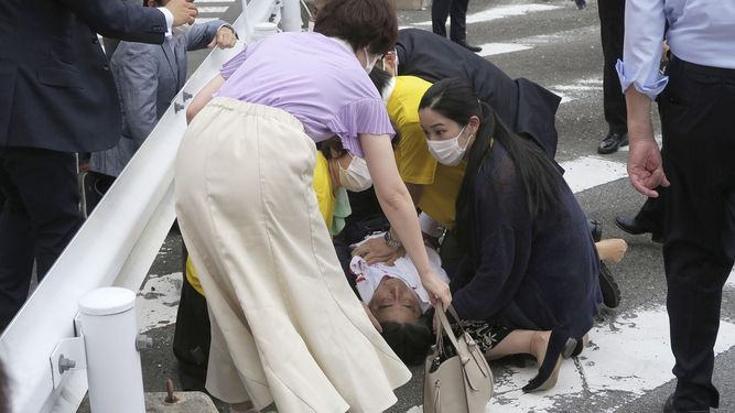 El ex primer ministro japonés Shinzo Abe, al centro, yace en el piso tras ser baleado el viernes 8 de julio de 2022, en Nara, en el oeste de Japón. Abe presentaba falla cardiaca, indicó la televisora NHK.&nbsp;