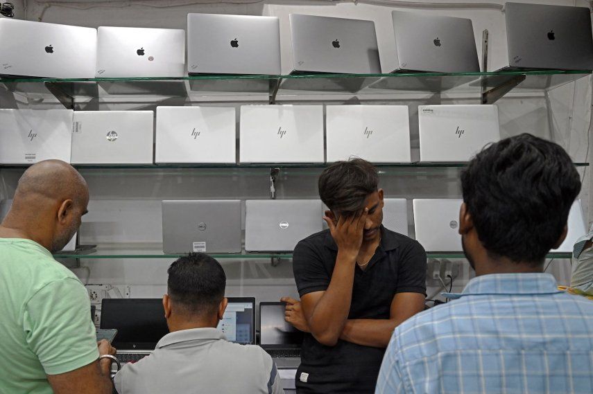 Un trabajador gesticula junto a las computadoras portátiles expuestas en una tienda de computadoras y accesorios en el mercado de electrónica de Nueva Delhi, India, el 4 de julio de 2025. 