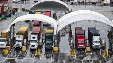 Camiones que transportan contenedores de envío se ven en el Puerto de Miami, Florida, el 7 de agosto de 2025.