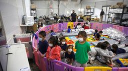 Niños migrantes de tres a nueve años de edad juegan o miran televisión en una instalación del servicio de Aduanas y Protección Fronteriza de EEUU en Donna, Texas, el 30 de marzo del 2021.
