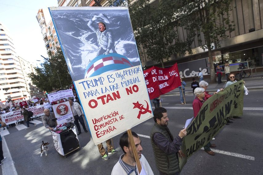 Un manifestante porta una pancarta en contra del presidente Donald Trump, durante la marcha que con motivo del Primero de Mayo, ha recorrido este lunes el centro de Murcia, España.