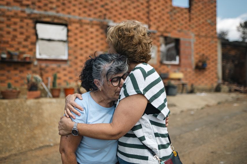 Vecinos de Castrocalbón junto a una vivienda que ha sido destruida por los incendios, a 20 de agosto de 2025, en Castrocalbón, León, Castilla y León (España).&nbsp;