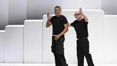 Los diseñadores de moda italianos Stefano Gabbana (izquierda) y Domenico Dolce saludan al público al final de la presentación de las creaciones de Dolce & Gabbana para la colección prêt-à-porter masculina Primavera-Verano 2026, en el marco de la Semana de la Moda de Milán, en Milán, el 21 de junio de 2025.
