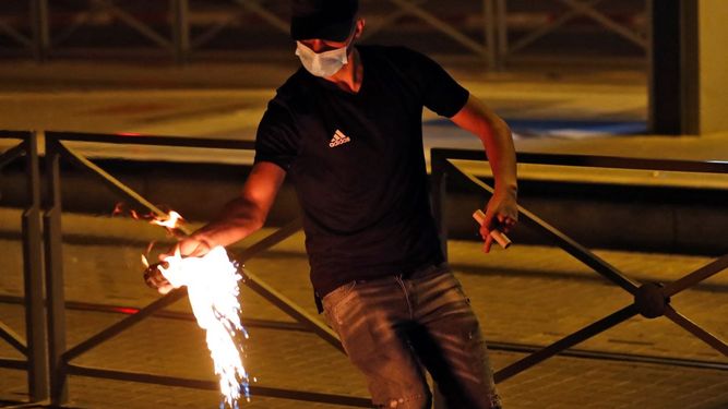 Un manifestante palestino lanza un cóctel molotov durante los enfrentamientos con las fuerzas israelíes en el campamento de Shuafat para refugiados palestinos, vecino al asentamiento israelí de Ramat Shlomo, en el este de Jerusalén anexado por Israel el 14 de mayo de 2021.