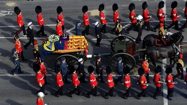 Esta vista aérea muestra a los guardias marchando junto al ataúd de la reina Isabel II, adornados con un estandarte real y la corona del estado imperial y tirados por un carruaje de artillería a caballo real de la tropa del rey, durante una procesión desde el Palacio de Buckingham hasta el Palacio de Westminster en Londres el 14 de septiembre de 2022.