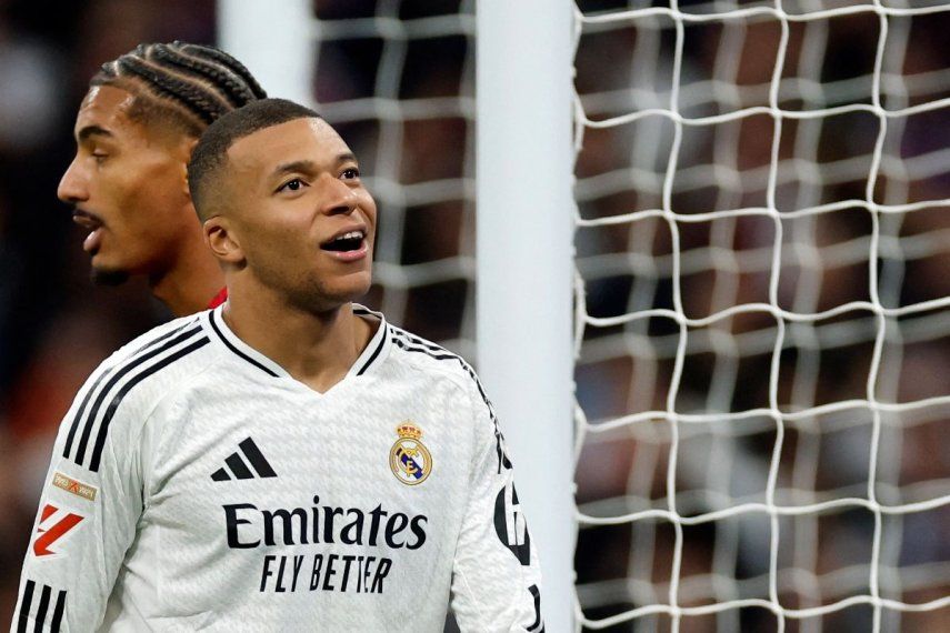 El delantero francés #09 del Real Madrid, Kylian Mbappé (R), reacciona después de perder una oportunidad de marcar durante el partido de fútbol de la liga española entre el Real Madrid CF y el Sevilla FC en el estadio Santiago Bernabéu en Madrid el 22 de diciembre de 2024.