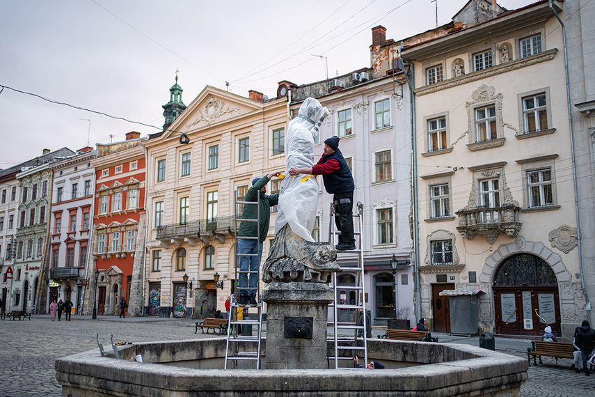 Operarios protegen una de las estatuas que engalanan la localidad de Lviv, en el oeste de Ucrania.