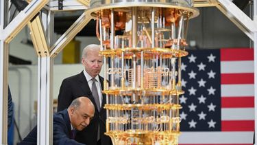 Un experto de la empresa IBM muestra al presidente Joe Biden un dispositivo de tecnología.