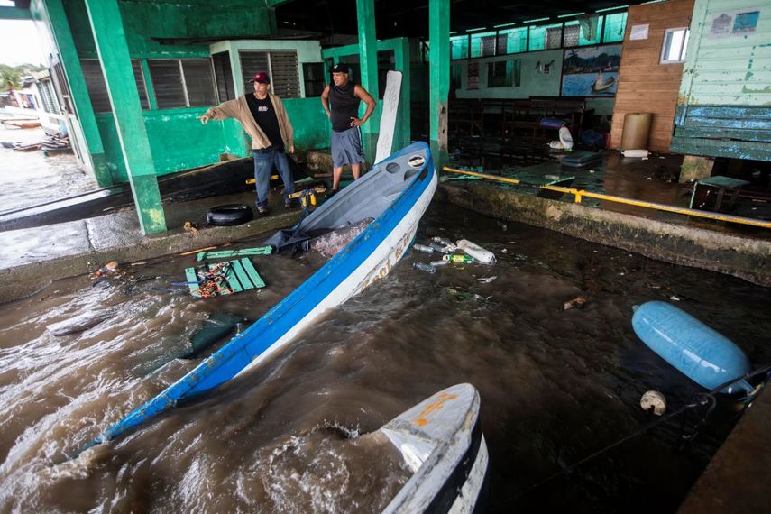 Los pescadores miran los botes parcialmente sumergidos en el agua después de que el huracán Julia azotara el área en Bluefields, Nicaragua, el domingo 9 de octubre de 2022.