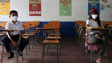 Estudiantes mantienen distancia social el primer día de regreso a la escuela presencial, en Antiguo Cuzcatlan, El Salvador, el martes 6 de abril de 2021. El Salvador reabrió sus escuelas el martes para el aprendizaje en persona más de un año después del cierre debido a la pandemia de coronavirus.