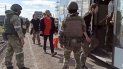 En esta foto tomada de un video distribuido por el Servicio de Prensa del Ministerio de Defensa ruso el martes 17 de mayo de 2022, soldados rusos observan a combatientes ucranianos evacuados de la acería Azovstal en Mariúpol, Ucrania. 
