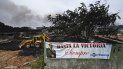 Una pancarta que dice Hasta la Victoria Siempre y que representa al difunto líder cubano Fidel Castro se ve mientras una excavadora trabaja en un área afectada del depósito de combustible que estuvo envuelto en llamas durante cinco días después de que cayó un rayo. uno de sus tanques, en Matanzas, Cuba, el 10 de agosto de 2022.&nbsp;