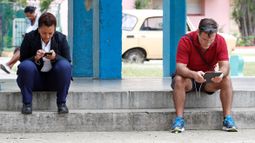 Varias personas navegan por internet con sus celulares desde un portal en La Habana el 15 de enero de 2019.