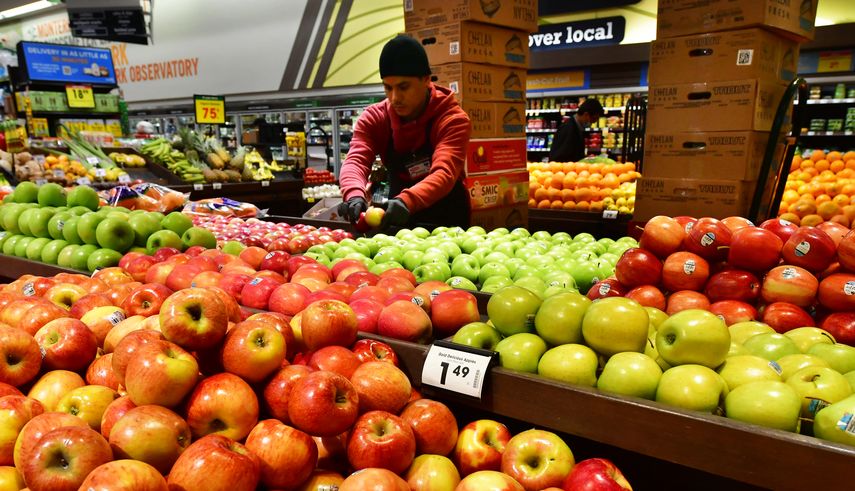 Un empleado organiza las frutas en un supermercado en EEUU.
