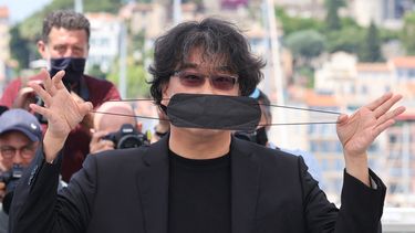 El director surcoreano Bong Joon-Ho juega con su mascarilla durante un photocall para el Rendez-Vous With en la 74 edición del Festival de Cine de Cannes en Cannes, sur de Francia, el 7 de julio de 2021.