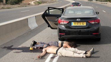 Los cuerpos de civiles muertos en un ataque militante palestino se encuentran en una carretera principal de la ciudad de Sderot, en el sur de Israel, el 7 de octubre de 2023.   
