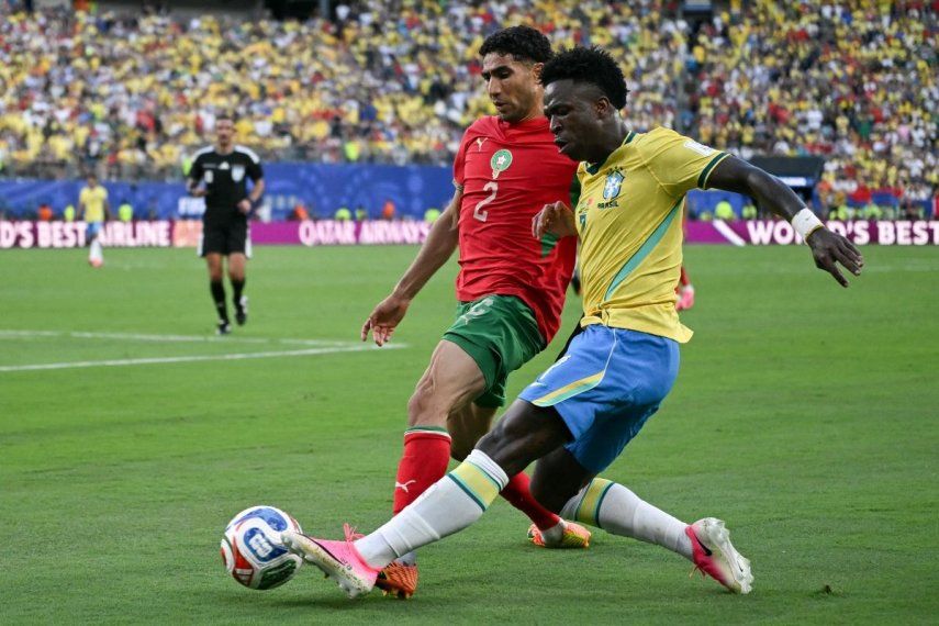 El capitán de Marruecos, Achraf Hakimi (izq), y el atacante de Brasil, Vinicius Jr., disputan el balón durante un partido entre ambas selecciones en el Mundial, el 13 de junio de 2026.