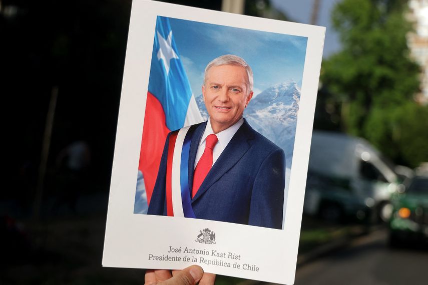 Una persona muestra un cartel con la imagen del candidato presidencial chileno José Antonio Kast, del Partido Republicano, en el que se lee su nombre y Presidente de la República de Chile, tras conocerse los primeros resultados de la segunda vuelta de las elecciones presidenciales en Santiago, el 14 de diciembre de 2025.&nbsp;