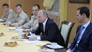El presidente ruso, Vladimir&nbsp;Putin&nbsp;(2-dha), y su homólogo sirio, Bashar al-Assad (dcha), se reúnen con los militares de la base aérea de Hmeimim, al sudeste de Latakia, Siria.