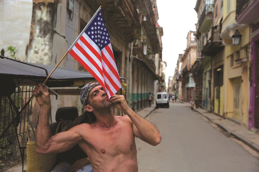 Un hombre besa la bandera de los Estados Unidos en una calle de La Habana.