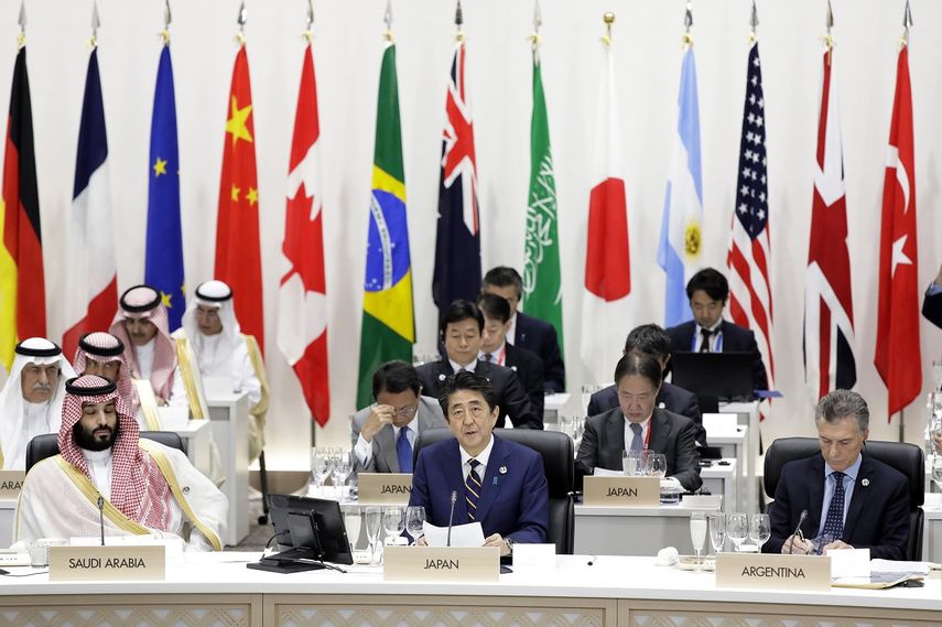 El primer ministro de Japón, Shinzo Abe (1ra fila, centro), habla entre el príncipe heredero de Arabia Saudí, Mohammed bin Salman (1ra fila, izquierda), y el presidente de Argentina Mauricio Macri&nbsp; (1ra fila, derecha), durante una comida de trabajo en la cumbre del G20 en Osaka, el 28 de junio de 2019.&nbsp;