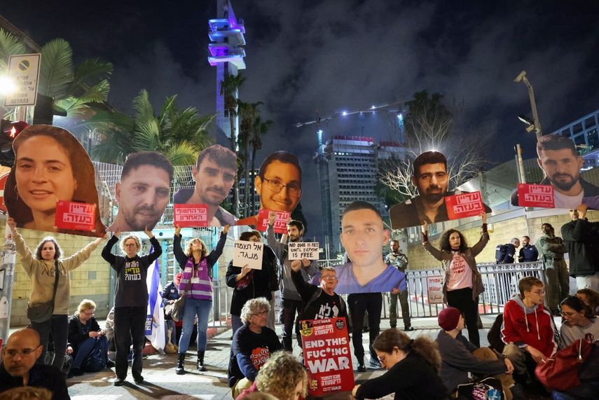 Familiares y amigos de israelíes tomados como rehenes por militantes palestinos en Gaza desde octubre de 2023 levantan carteles mientras se manifiestan para exigir acciones para su liberación, frente al Ministerio de Defensa israelí en Tel Aviv el 8 de marzo de 2025