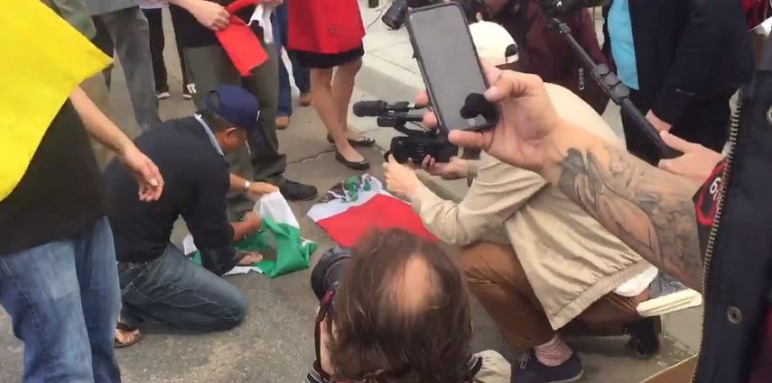 En el acto pro Trump en Otay, un manifestante rompe una bandera mexicana.