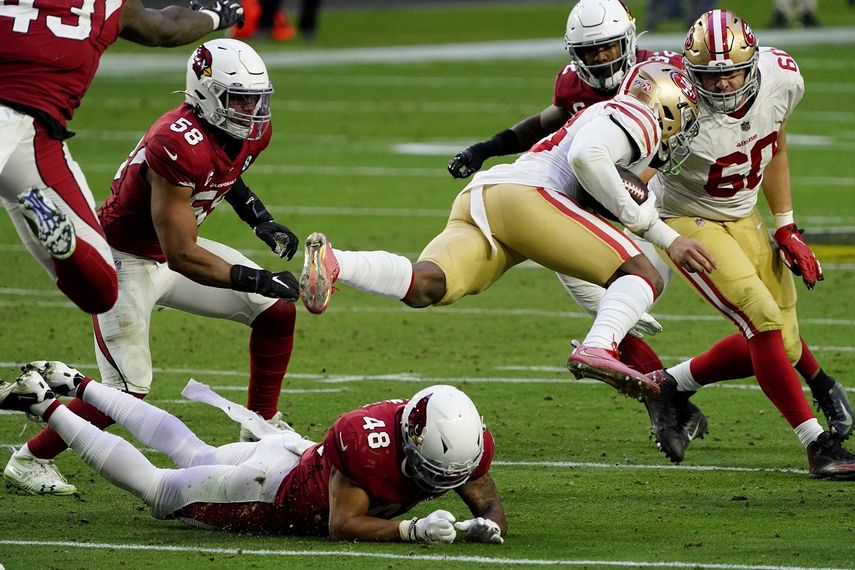 Jerick McKinnon, corredor de los 49ers de San Francisco, es derribado por Isaiah Simmons (48), linebacker de los Cardinals de Arizona, en el partido dle sábado 26 de diciembre de 2020, en Glendale.