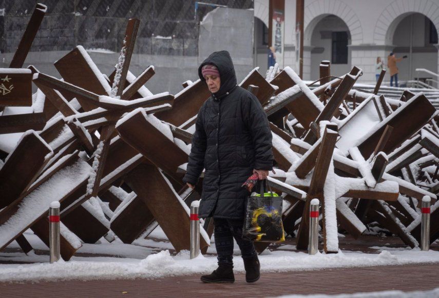 Una mujer camina frente a una barricada antitanques, el lunes 12 de diciembre de 2022, en Kiev, Ucrania.&nbsp;