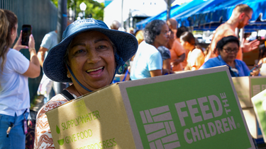 Una residente de Miami sonríe después de recibir ayudas en Miami.