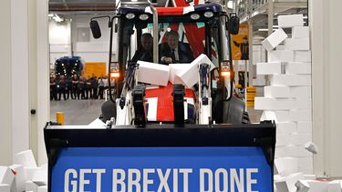 En esta foto de archivo tomada el 10 de diciembre de 2019, el primer ministro británico y líder del partido conservador Boris Johnson conduce un JCB con el tema de la bandera de la Unión, con las palabras Get Brexit Done dentro del cubo de la excavadora, a través de una pared falsa con la palabra GRIDLOCK.&nbsp; &nbsp;