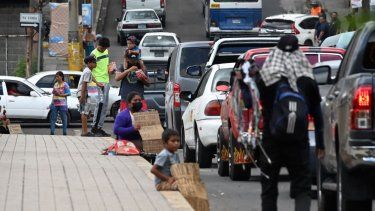 Migrantes venezolanos que intentan llegar a Estados Unidos piden dinero en una calle de Tegucigalpa el 19 de septiembre de 2023.