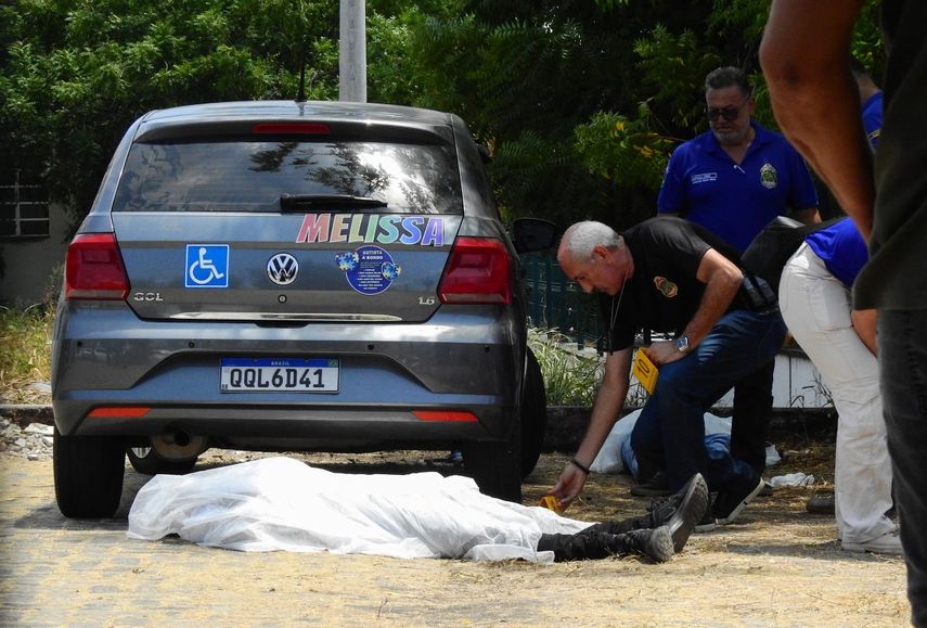 Agentes de la policía civil de Ceará revisan los cuerpos de dos adolescentes muertos en un tiroteo dentro del estacionamiento de una escuela pública en Sobral, estado de Ceará, Brasil, el 25 de septiembre de 2025.