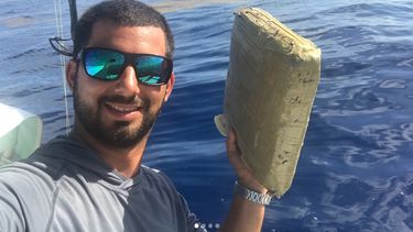 El fotógrafo Jorge Bustamante sostiene el paquete de marihuana que encontró en las costas de Pompano Beach.