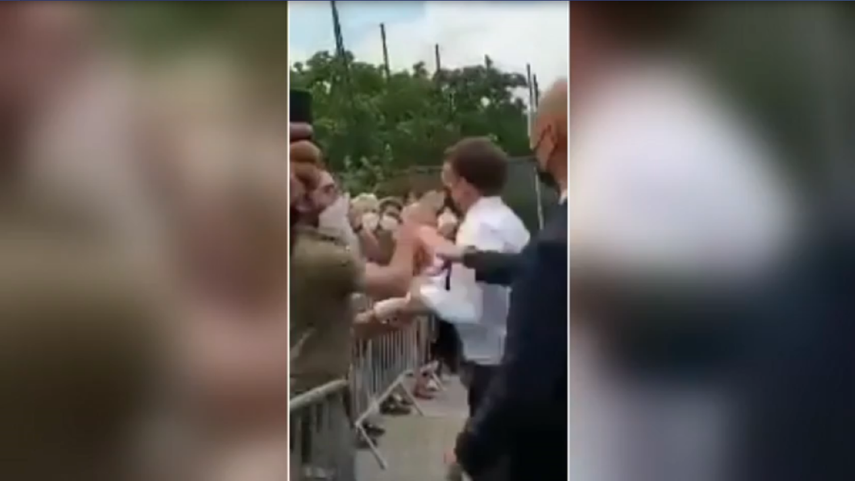Captura de pantalla de video en el momento que el presidente Emmanuel Macron recibe una bofetada de un individuo.