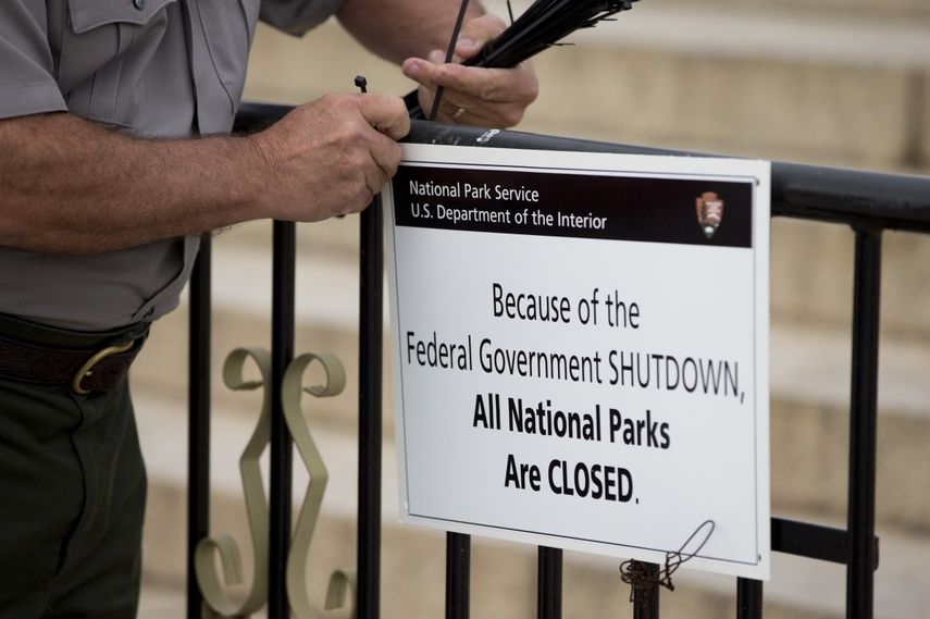 Un empleado coloca un cartel que anuncia el cierre de los parques nacionales. (AP)