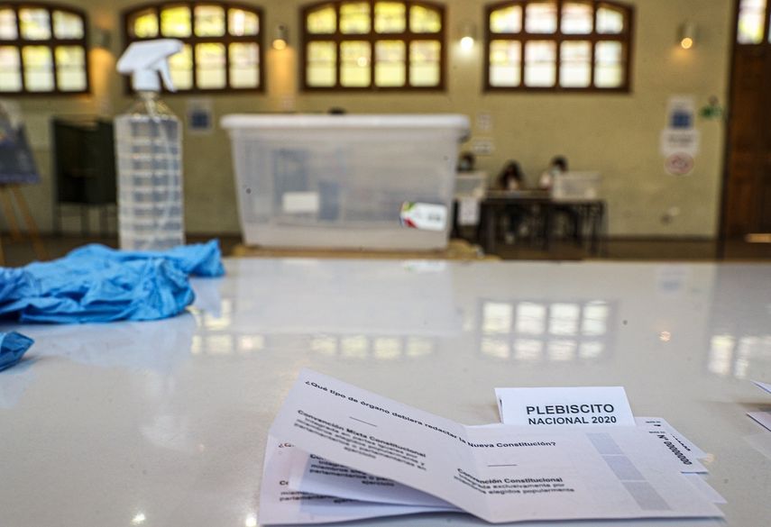 Boletas, guantes y alcohol están en una mesa en una escuela que servirá como centro de votación en Santiago, Chile, el viernes 23 de octubre de 2020.&nbsp;